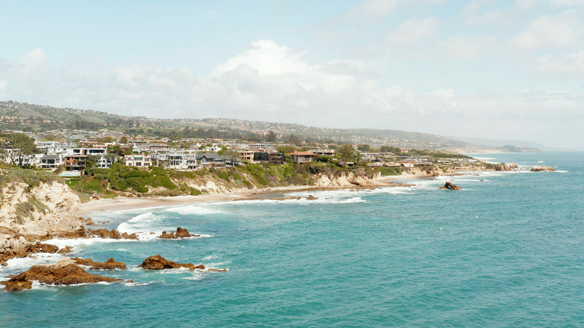 A coastal town with blue water in the forefront. 