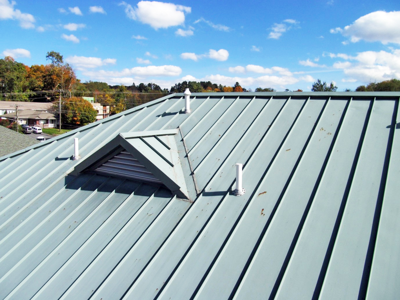 An aged, light blue metal roof showing signs of corrosion