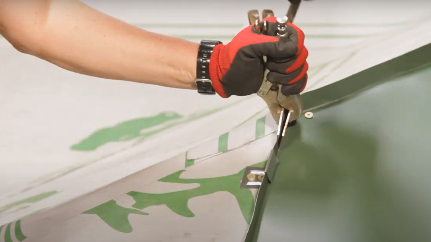 Close up of someone using flangers for bending metal roofing trim. 